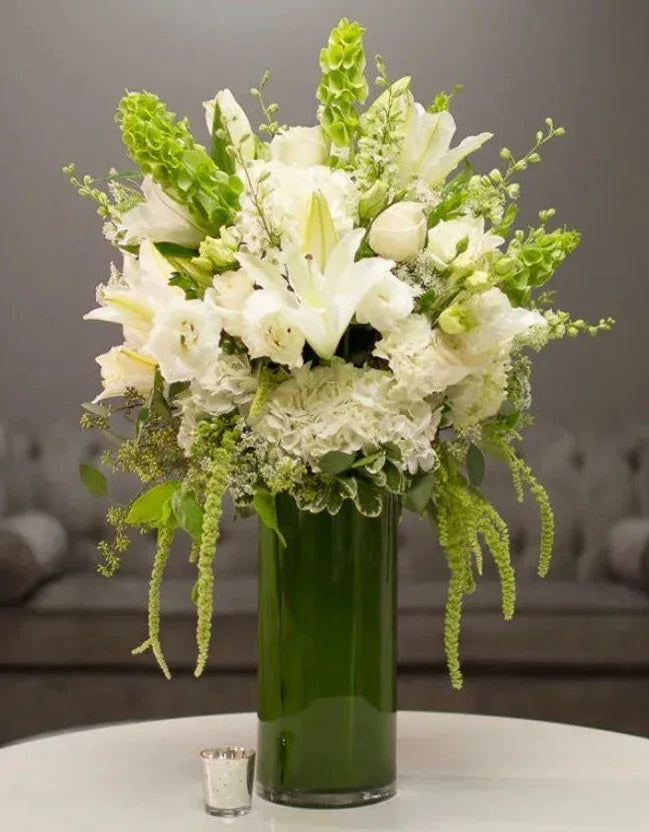 Elegant white & green floral arrangement in a leaf-lined clear glass vase